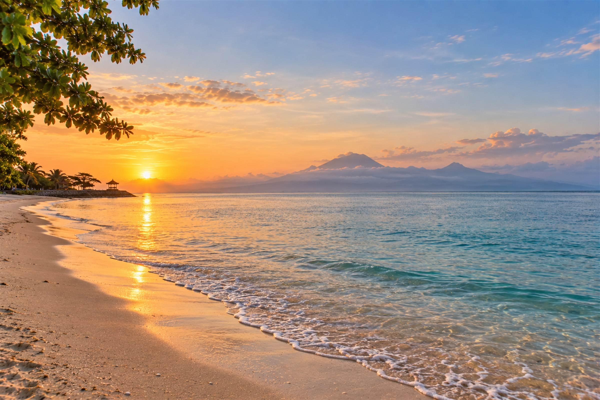 Sanur beach at sunrise, with the volcanoes of Bali across the water