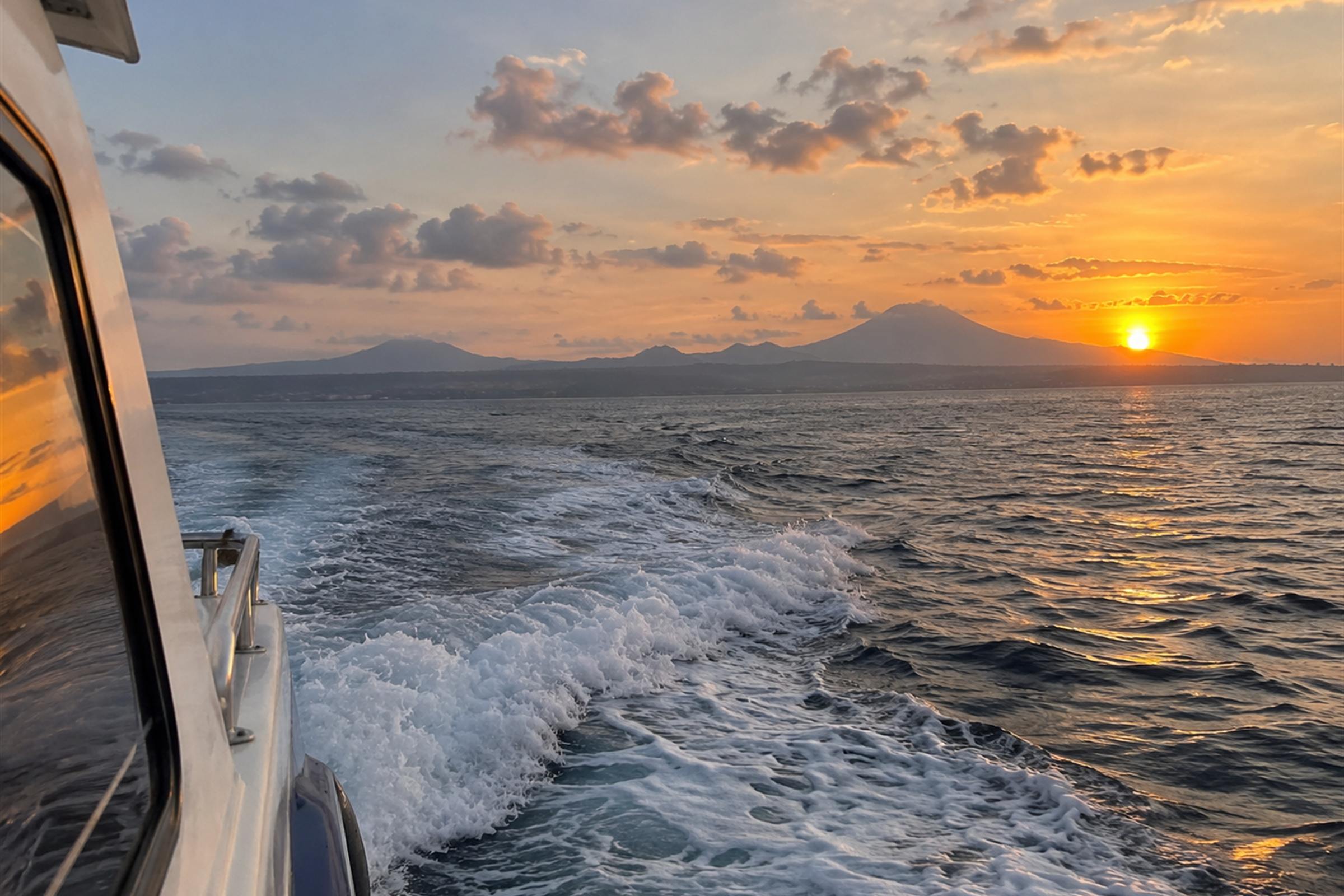 The wake of the boat crossing back towards Bali at sunset