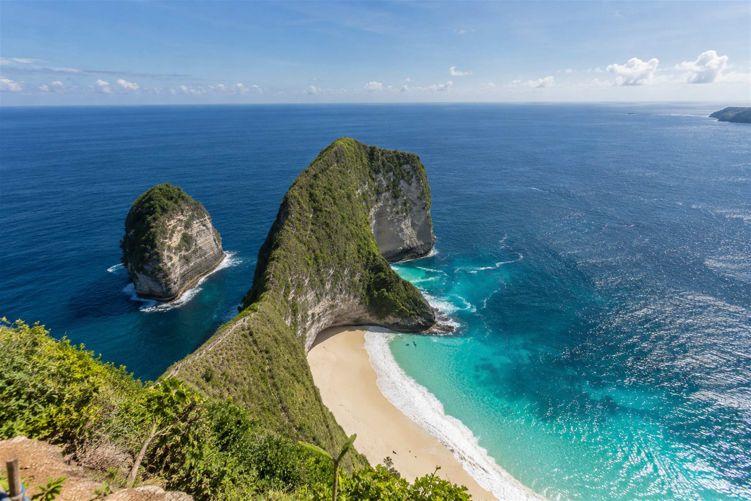 The green Kelingking headland on Nusa Penida curving down to a white sand cove and turquoise water